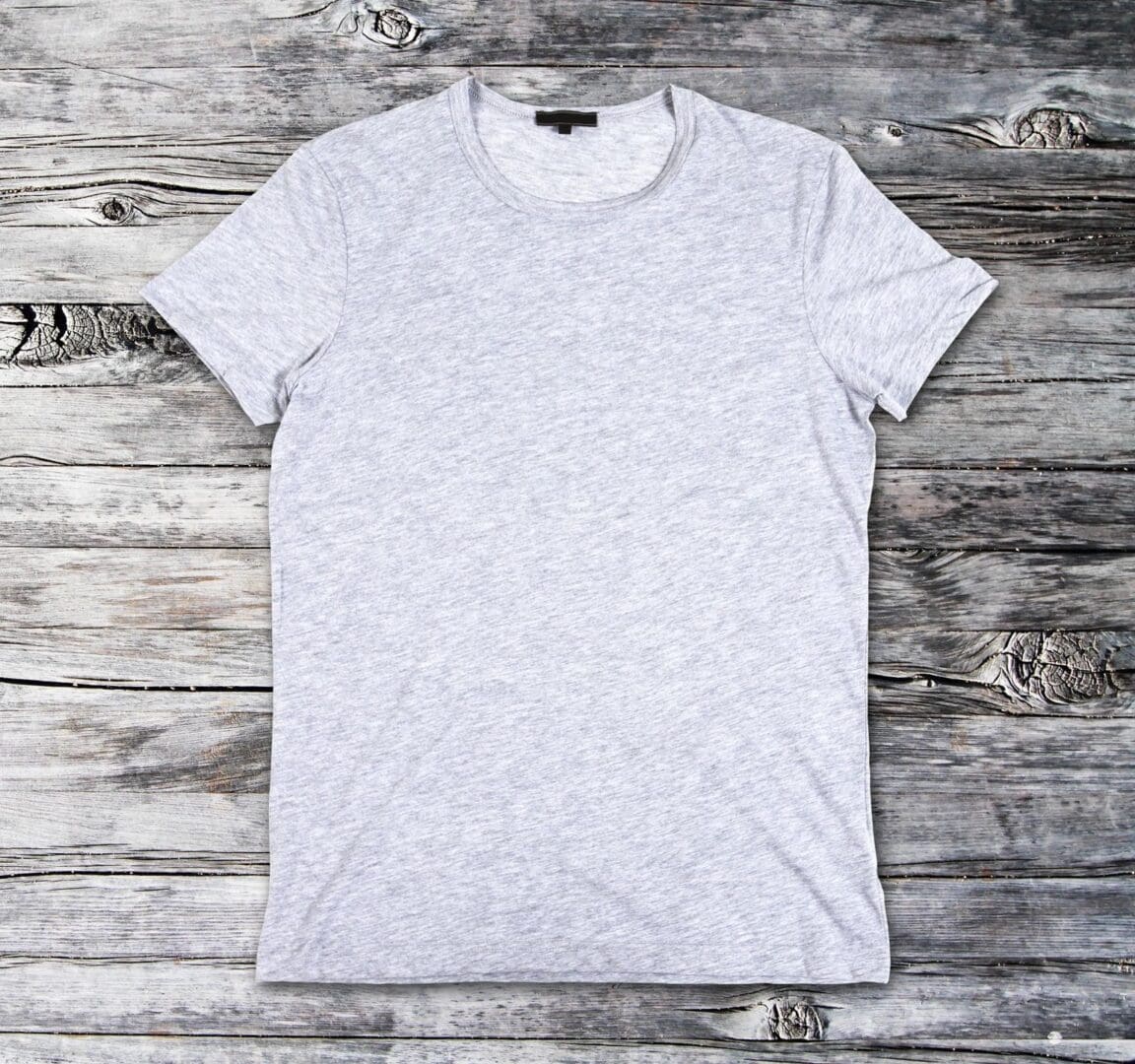 A grey T-Shirt on a wooden background.