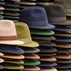 Many different colored Hats are lined up in a row.