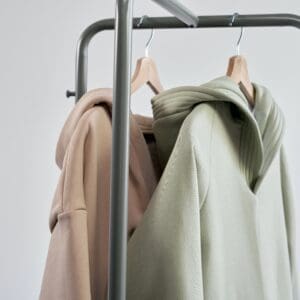 Two sweatshirts hanging on a metal rack.