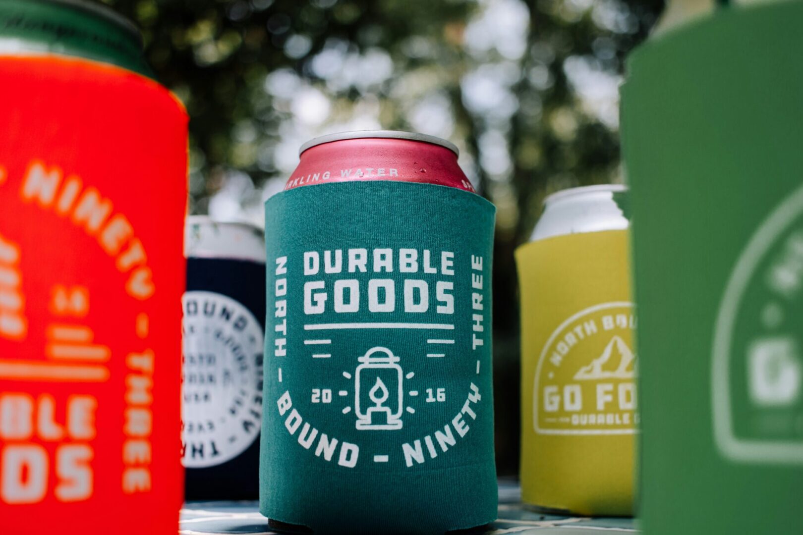 A group of coozies with the words 'diverse goods' on them.