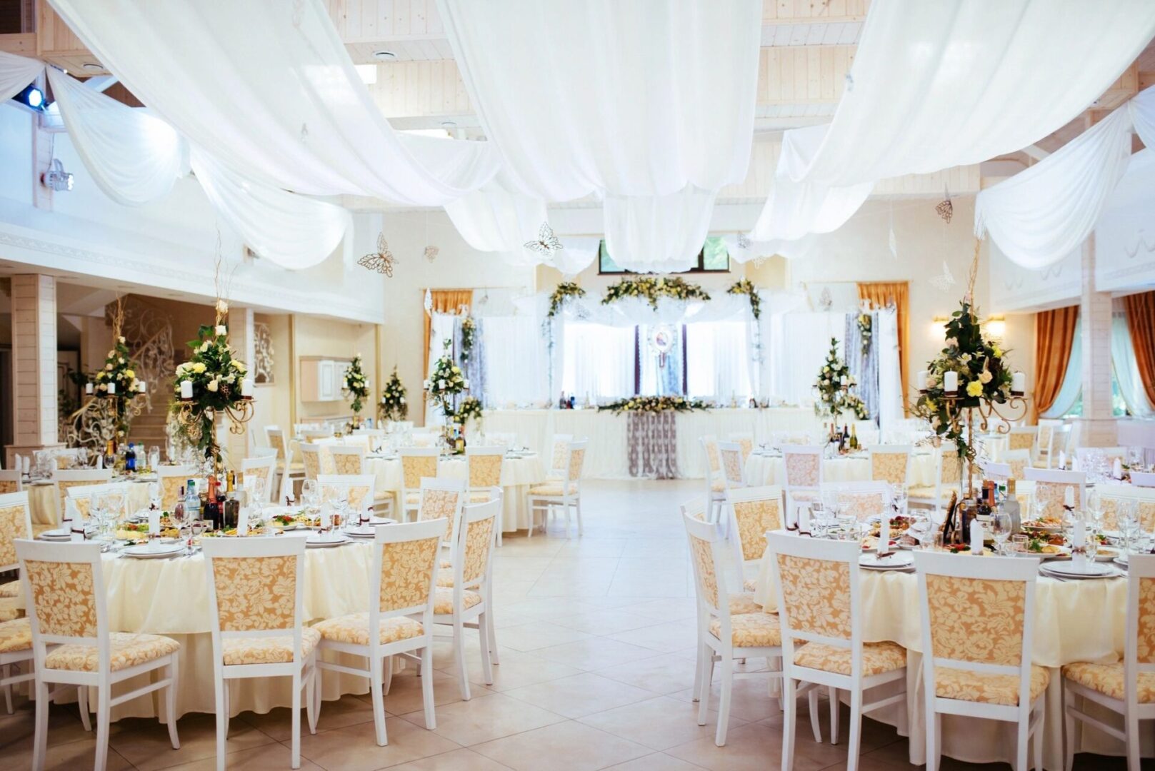 A wedding reception in a Banquet Room Booking with white drapes.