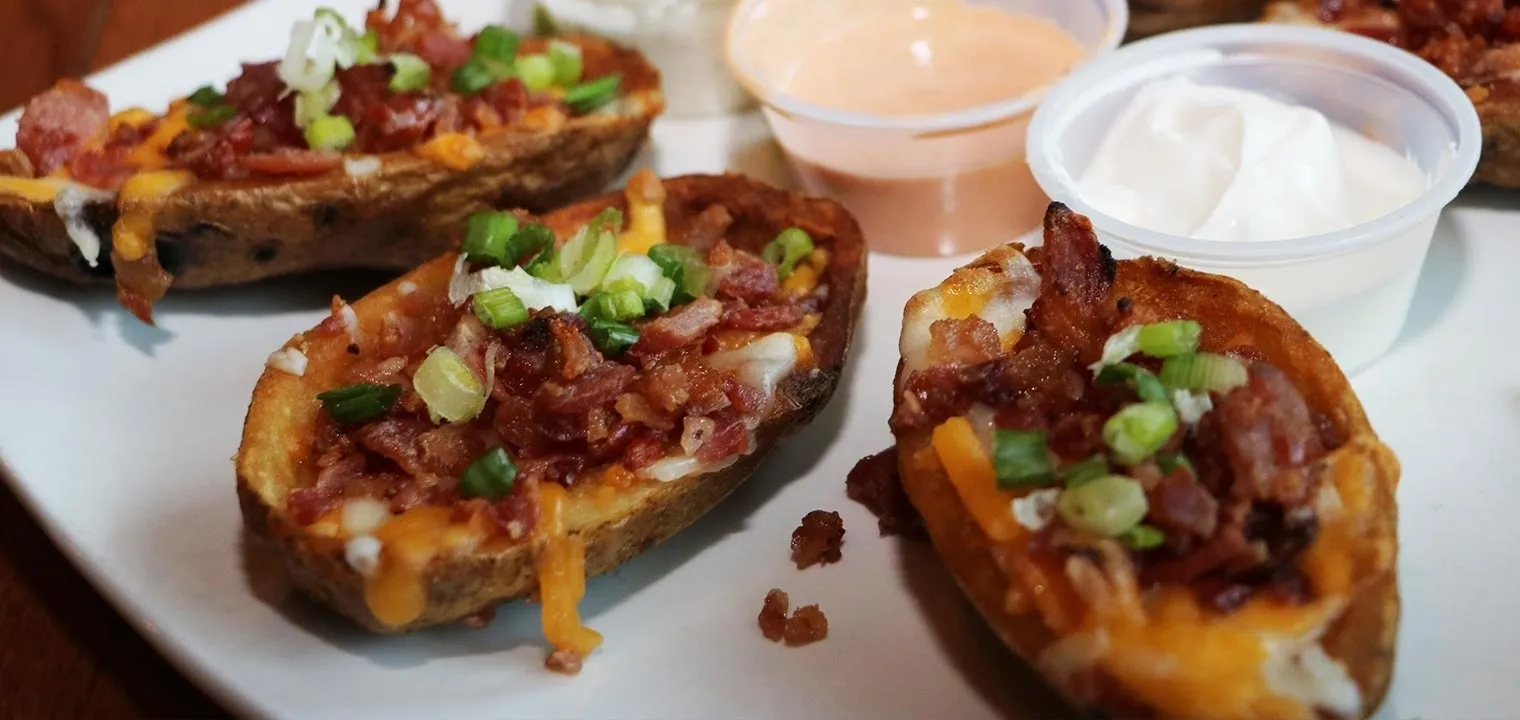 Stuffed potatoes with bacon and sour cream on a plate.