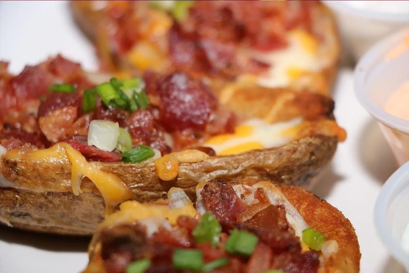 Stuffed potatoes with bacon and cheese on a plate.